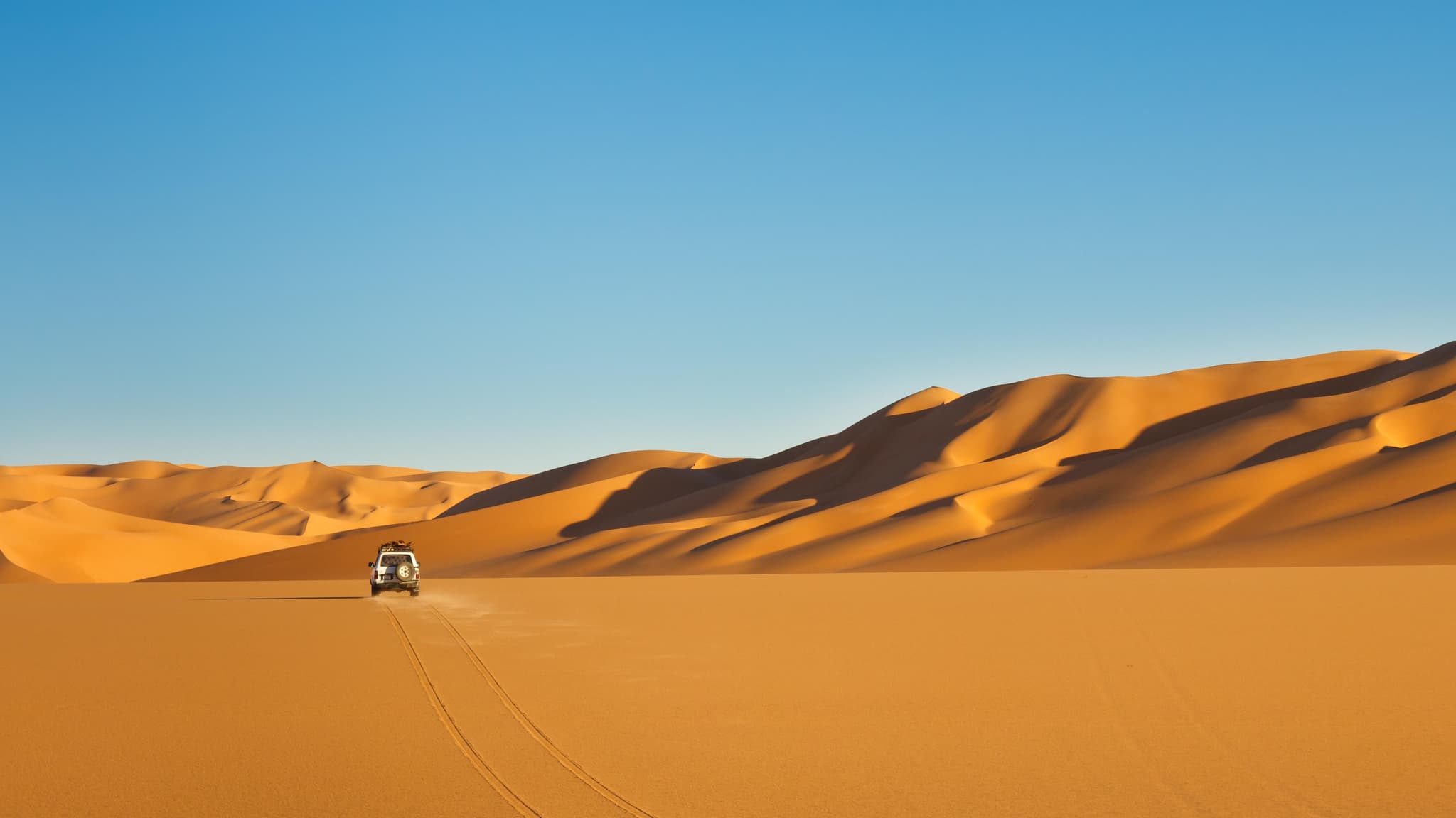 4x4 expedition vehicle driving across Namibian desert sand dunes